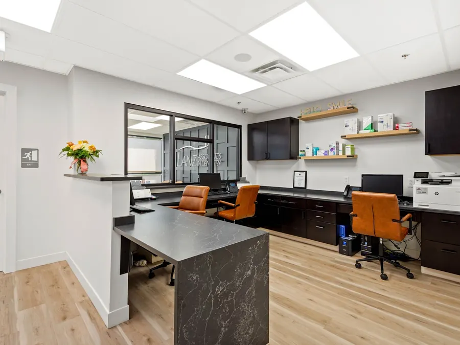The front desk at the Mt. Lebanon office, with a stone-topped reception counter and staff workstations behind.